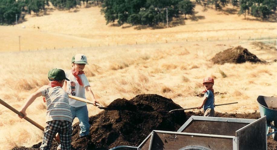 farmer boys shoveling compost on Capay farm